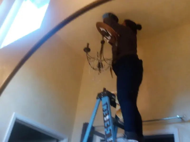 Electrician installing a chandelier in a Pocatello residence